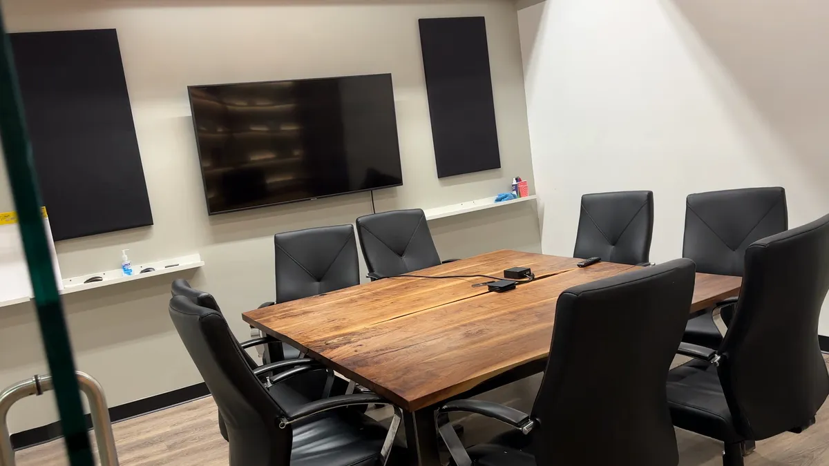 The conference room at The Lodge with a live-edge table behind black-framed glass