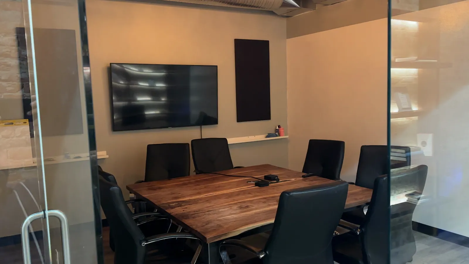 The conference room at The Lodge with a live-edge walnut table and acoustic panels