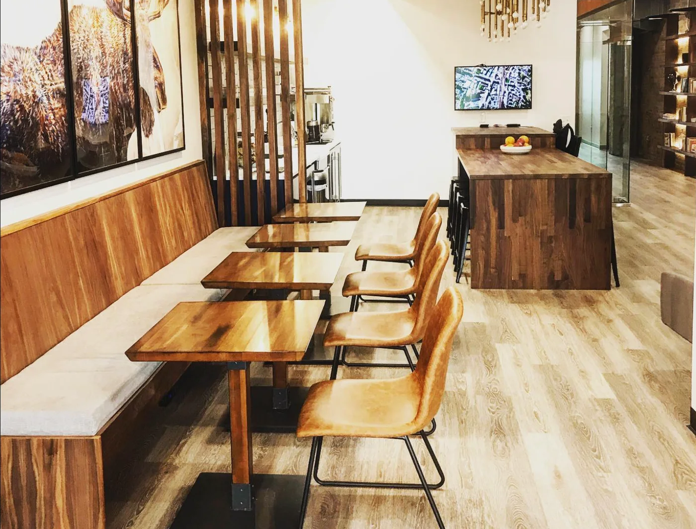 Comfortable cafe seating at The Lodge with leather chairs, walnut tables, and framed art