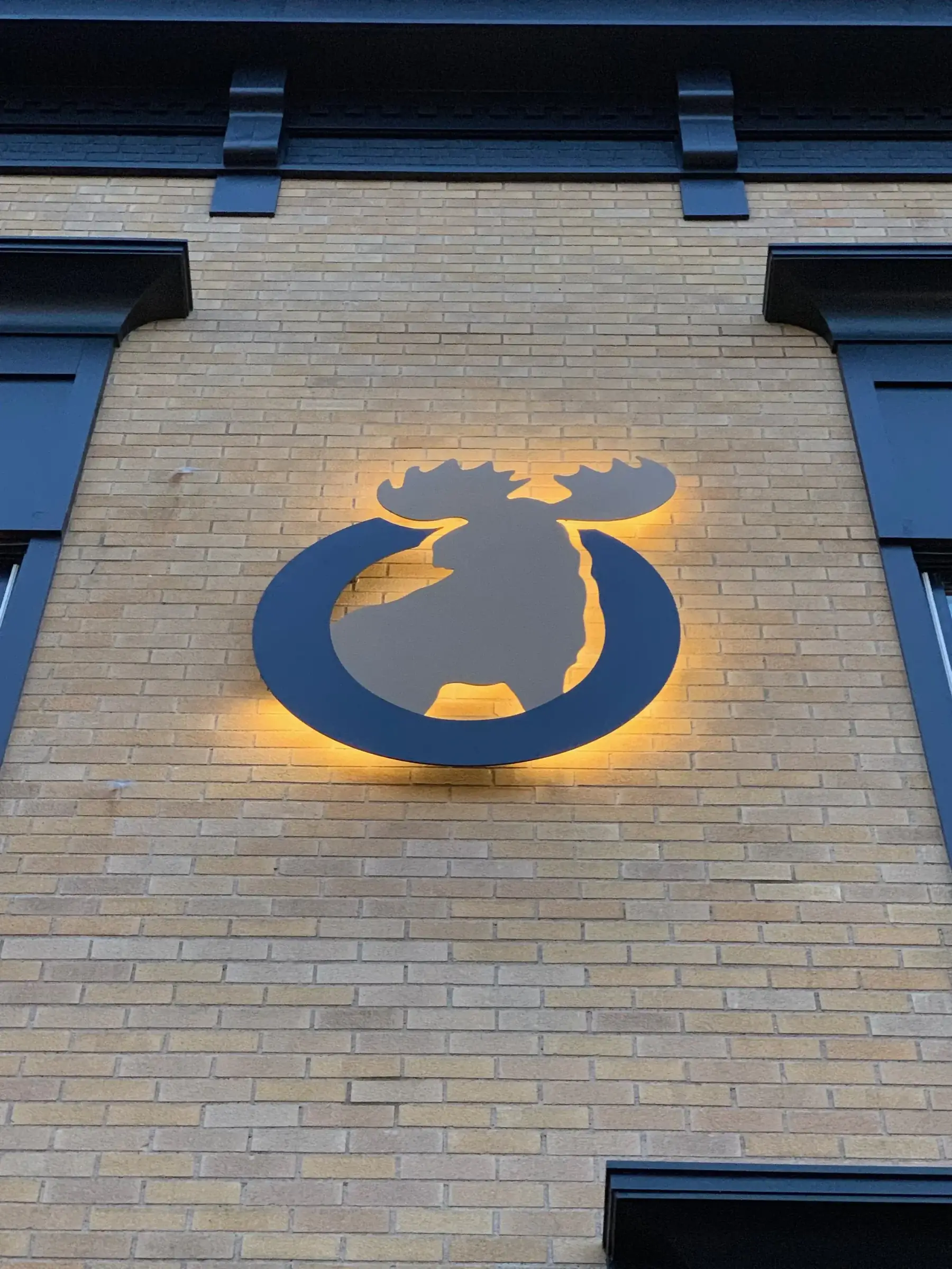 The historic Lodge building with the backlit Moose emblem on brick