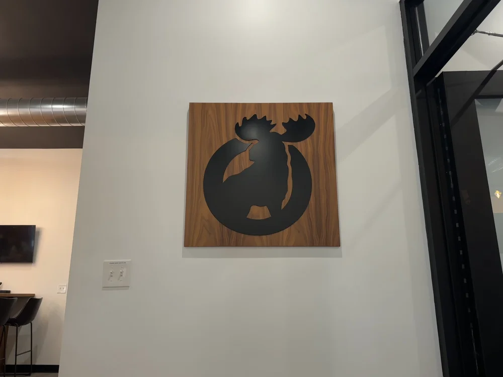 A framed Moose crest hung on the wall at The Lodge, a nod to the building's Moose Lodge years