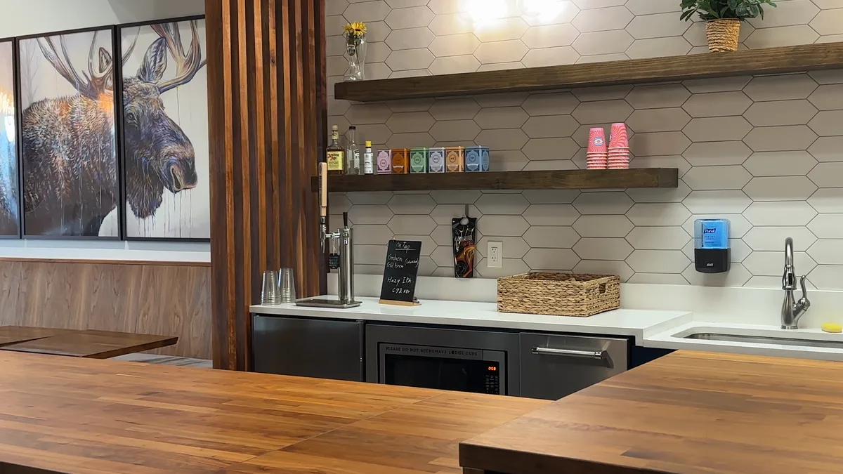 The coffee bar at The Lodge with a walnut counter, open shelving, and Moose artwork